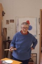 Ann O'Hanlon with hand on hip while painting in studio, 1977