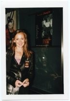 Laura Harrison, director/producer, standing with her film's poster, 1999