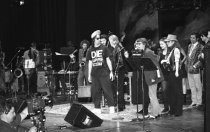 Syd Straw singing with a group of musicians at a Tribute to Hal Willner, 1990