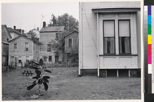 [Clapboard houses and yard with swing set.]