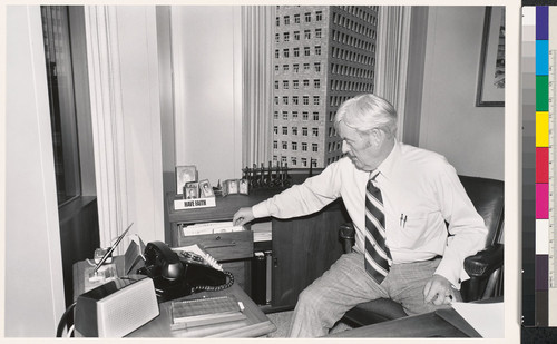 [Office worker seated at a desk, pulling something out of drawer, Standard Oil Company of California.]