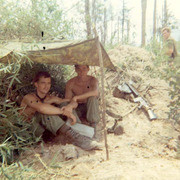 Photograph of Gustafsson and A Fellow Soldier Sitting Under A Tent in the Countryside of Vietnam