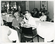 Photograph of Acevedo Sitting in A Community Gathering Room With Presumably His Wife, Maria