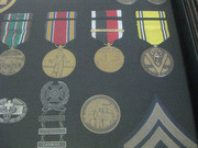 Enlarged Image of the Bottom-Right Section of the Framed Case With Acevedo's Military Honors, Awards, and Other Mementos