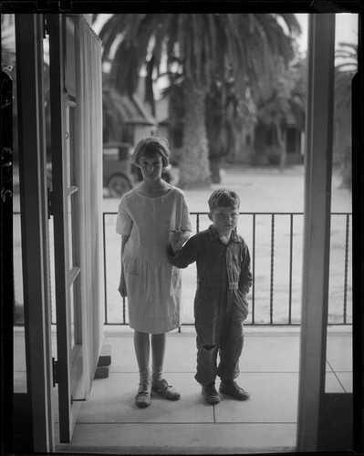 Children on porch looking through open door, Los Angeles, circa 1935