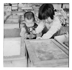 Older sister helping toddler brother, Korea