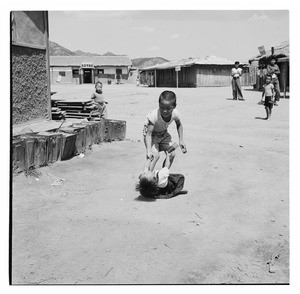 Children playing in courtyard outside of shops, Korea