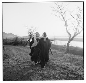 Three women walking single file in country, Korea