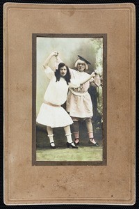 A cabinet studio colored portrait of two men in dresses, circa 1900s