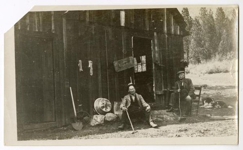 Men sitting outside a barn