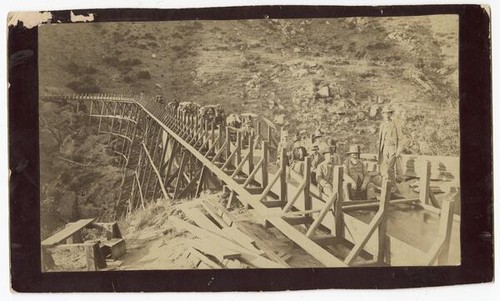 Women and men sitting on unfinished railroad tracks