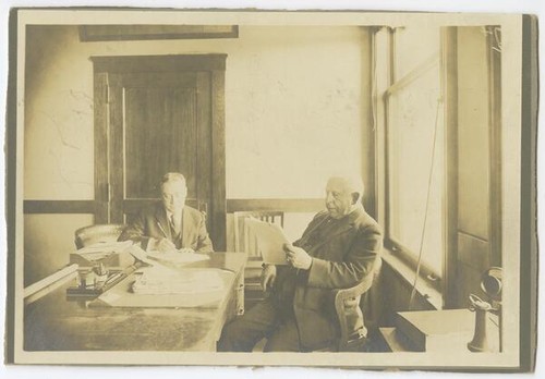 Reginaldo F. del Valle and unidentified man at desk