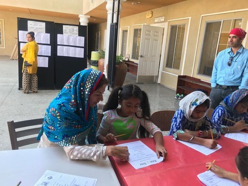 Pushpinder Kaur with Blue Scarf Teaching one Girl Student