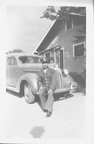 Arnulfo Sanchez in Uniform Sitting on a Car