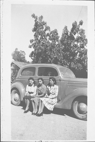 Three Young Women Sitting on Car