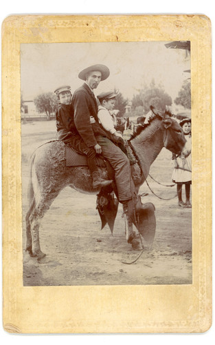 Two Boys and a Man on a Donkey