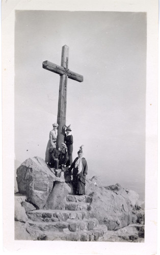 People Pose at Foot of Wooden Cross