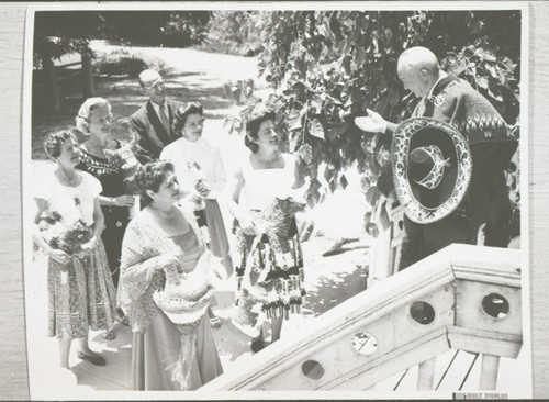 A Man in Spanish Costume Talks to a Group of Women