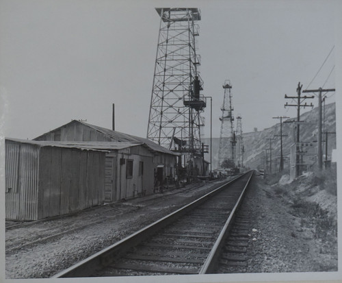 Standard Derricks Along Railroad Tracks