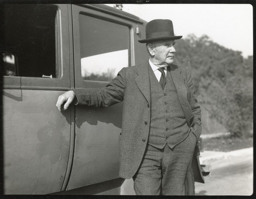 T. M. McFarland Leaning against Car