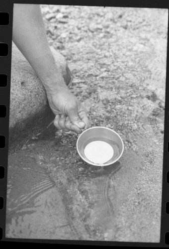 Backpacking. Visitor getting water from a stream