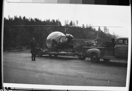 Flood and storm damage, helicopter activities, helicopter used to fly Rangers Bender, Martinek and their bicycles to Cedar Grove to inspect December 1955 flood damage. Pilot outside unidentified