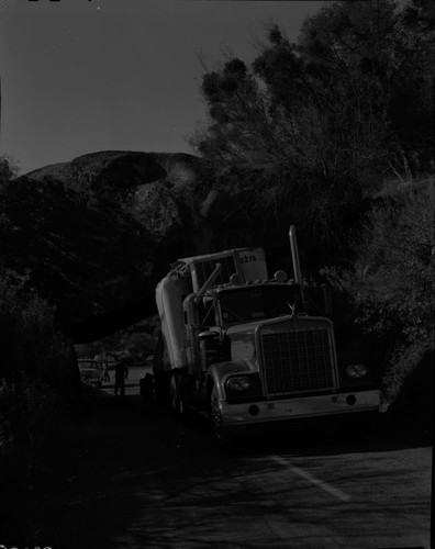 Wrecks, truck stuck under rock