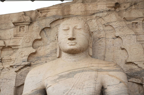 Gal Vihāra complex: Seated Buddha figure: Statue carved in rock: Face of Buddha: Cusped arch: Lotus motif