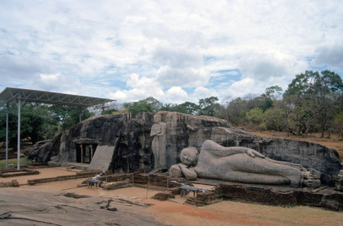 View of Gal Vihāra complex: Four large Buddha statues: Seated, standing and recumbent: "Buddhist" flag