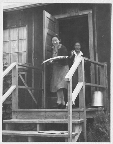 Two women exiting a camp building