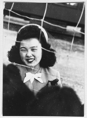 Young woman looks through fence