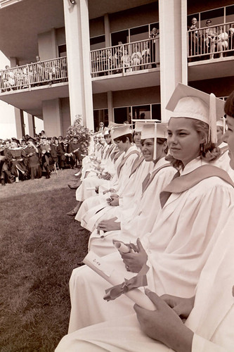 Front row seated graduates with diplomas