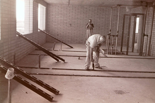 Two construction workers in the interior of Holden Hall