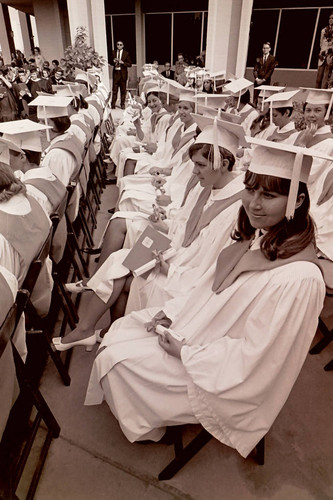 Seated graduates with diplomas