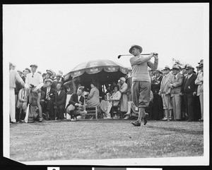 A golf tournament player while a crowd is watching, ca.1920
