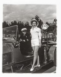 Miss Sonoma County, Sandra Duden, and Santa Rosa Fire Chief George H. Magee on the Santa Rosa 20-30 Club's old fire engine, "Engine Co. no. 50," Santa Rosa, California, 1958