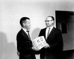 Charles Peck handing a KO polio cube to an unidentified man, Santa Rosa, California, 1962