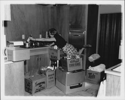 Peck family moving things into their kitchen, Santa Rosa, California, 1957