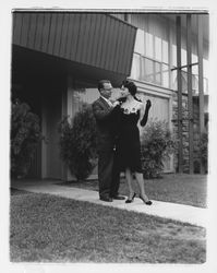 Unidentified man arranges a fur stole on Mrs. Willard Outlaw's shoulders at the Dramatic Moods of Autumn Fashion Show at the Flamingo Hotel, Santa Rosa, California, September 17, 1959