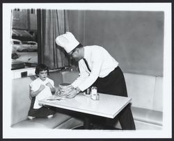 Kiwanis Club member serving a stack of pancakes to a little girl, Santa Rosa, California, 1961