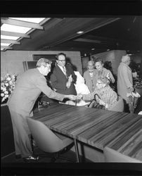 Harold "Hal" Trebbe talking to customers at the grand opening of the Bank of Sonoma County, Santa Rosa, California, September 18, 1965