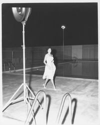 Unidentified Miss California contestant modeling a white evening dress in the Aqua Varieties fashion show at the Swim Center, Santa Rosa, California, 1959