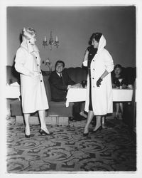 Two models with long coats in the "Dramatic Moods" fashion show in the Topaz Room, Santa Rosa, California, 1959