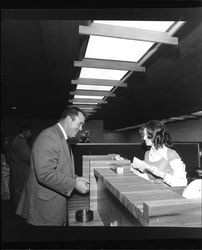 Sue Boehmer, teller, opening account for unidentified man at grand opening of Bank of Sonoma County, Santa Rosa, California, March 19, 1973