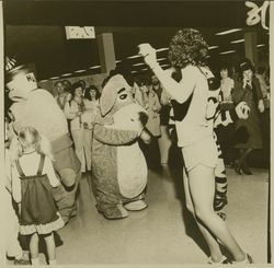 Eeyore and Tigger at Sears opening day celebration dancing with a girl in shorts, Santa Rosa, California, 1980