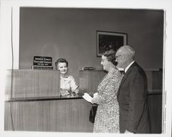 Nellie Urmann issuing travelers checks to a couple at the Exchange Bank, Santa Rosa, California, 1960