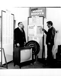 John Downey with unidentified men at boards listing entries and winners of vote getting game, Santa Rosa, California