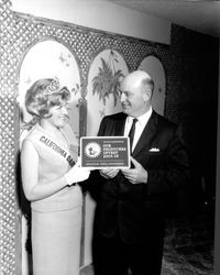 Harry Rasmussen receiving plaque from unidentified California Dairy Princess, Santa Rosa(?), California, February 2, 1965