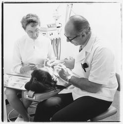 Unidentified dentist and assistant perform dental work on a patient in the Empire Dental Building, Santa Rosa, California, 1971