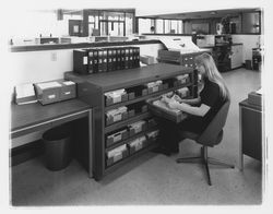 Exchange Bank staff member works at a file cabinet at the Coddingtown office of the Exchange Bank, Santa Rosa, California, 1972